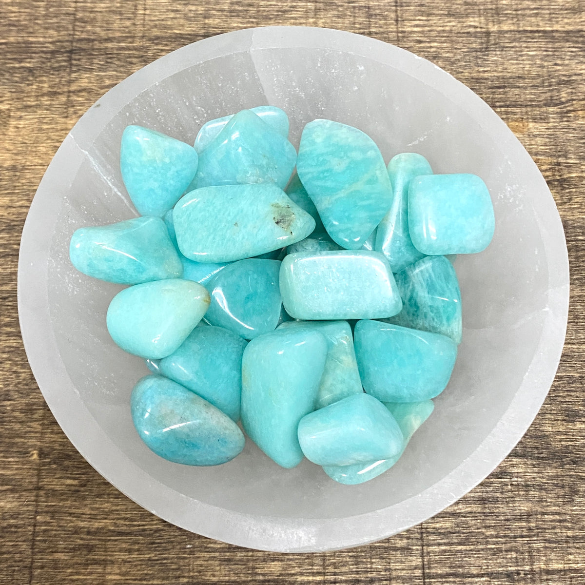 Overhead shot of various Amazonite tumbled stones in a small bowl.