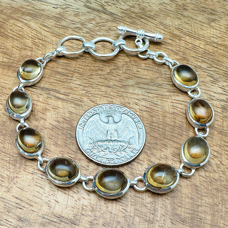 Comparison shot of a US quarter coin and a bracelet with citrine stones