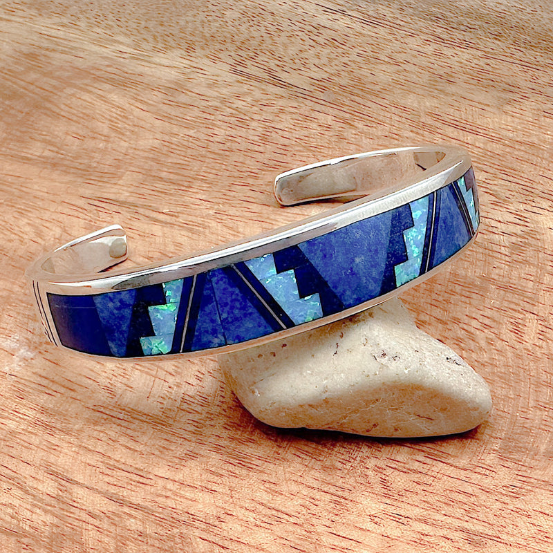 Shot of a blue sky inlay cuff bracelet laid upon a decorative rock