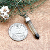 Comparison shot of a US quarter coin and a citrine point pendant