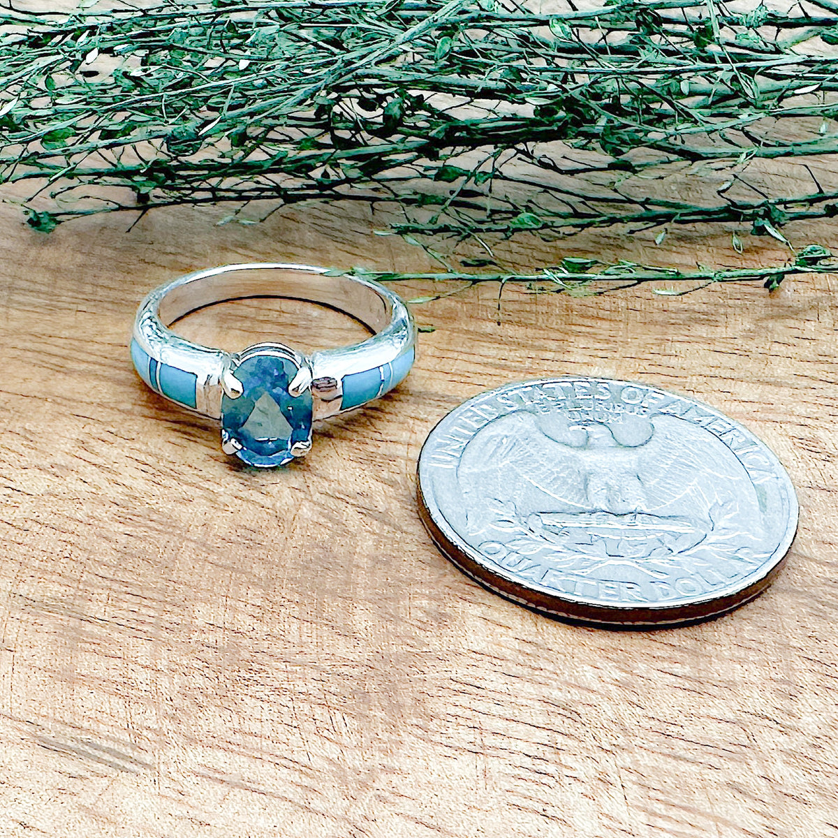 Size comparison of a US Quarter coin and a handmade sterling silver ring that has 6 hand cut stones with Sleeping Beauty Turquoise and a London Blue Topaz on top that is a part of the David Rosales collection.