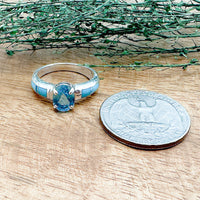 Size comparison of a US Quarter coin and a handmade sterling silver ring that has 6 hand cut stones with Sleeping Beauty Turquoise and a London Blue Topaz on top that is a part of the David Rosales collection.