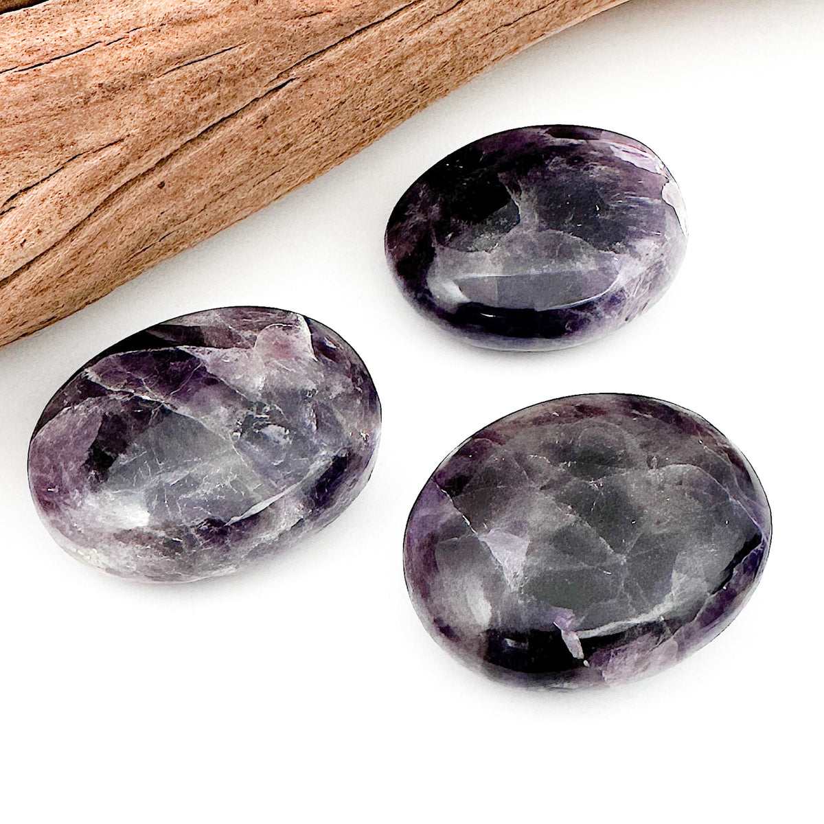Three amethyst palm stones placed together against a white background