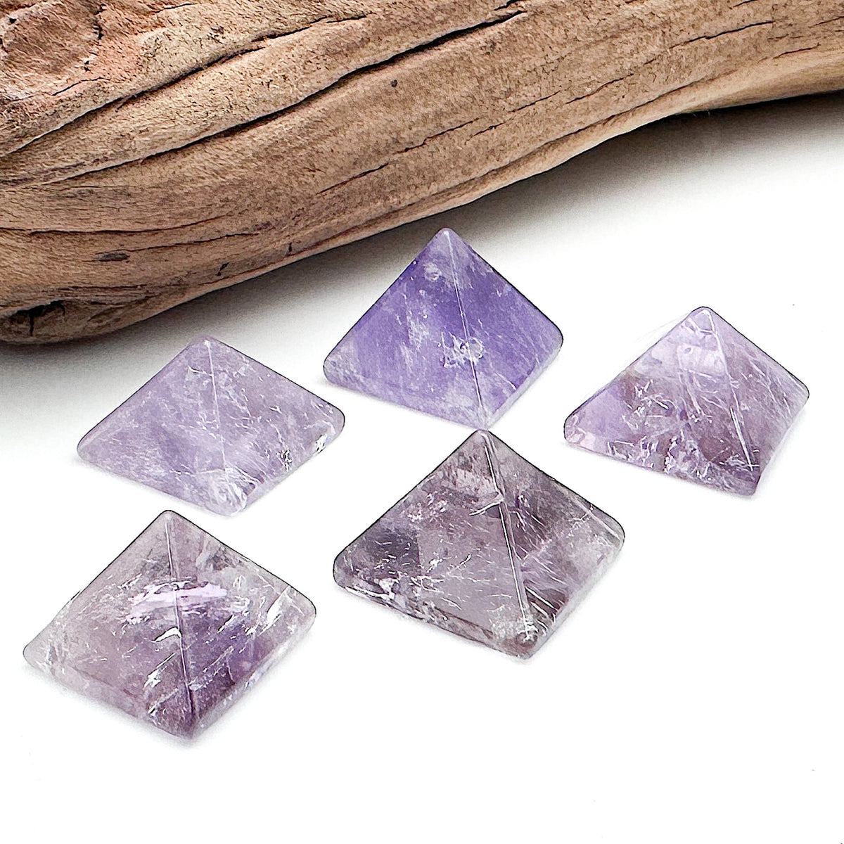 Various amethyst pyramids laid together against a white background