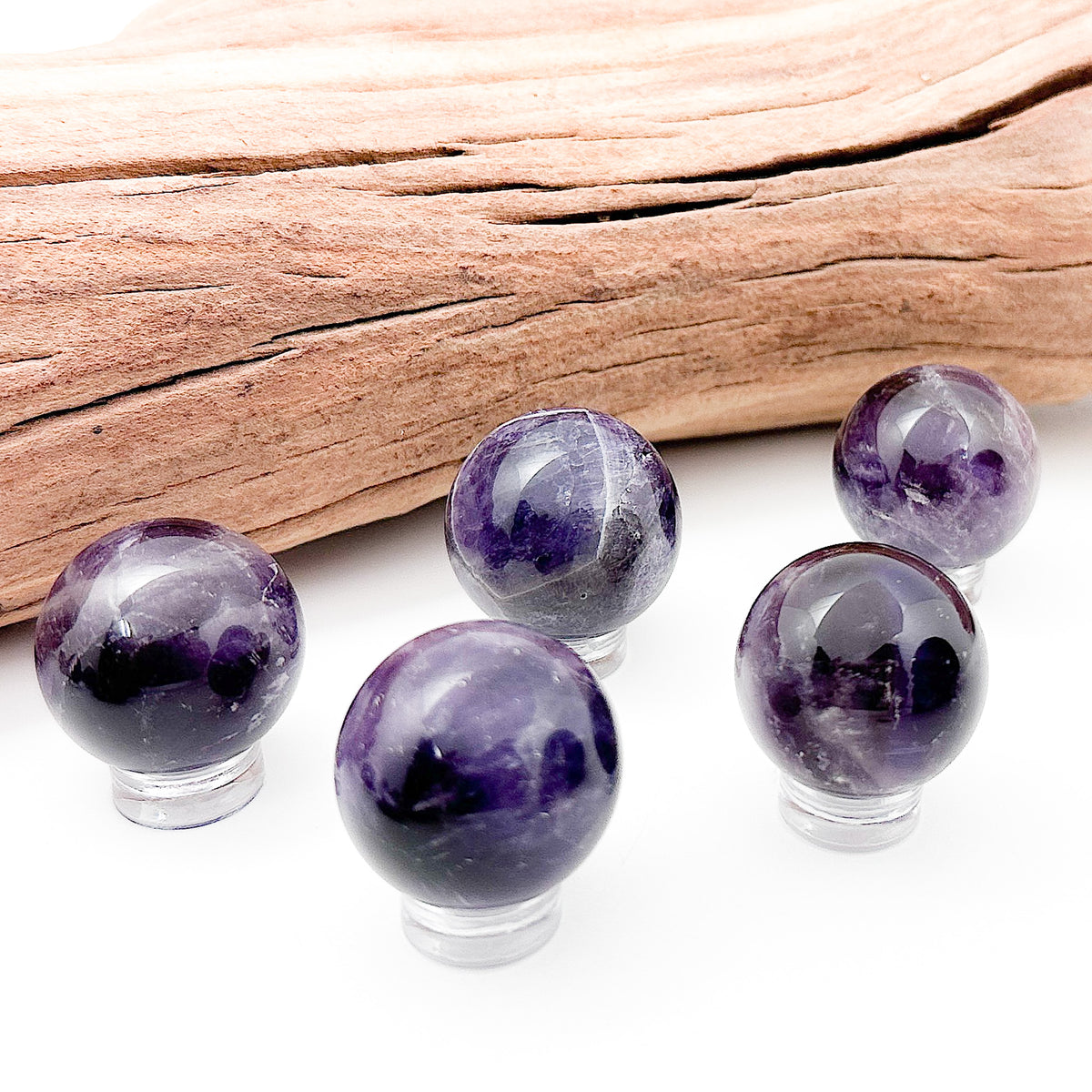Various amethyst spheres laid in a group against a white background
