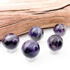 Various amethyst spheres laid in a group against a white background