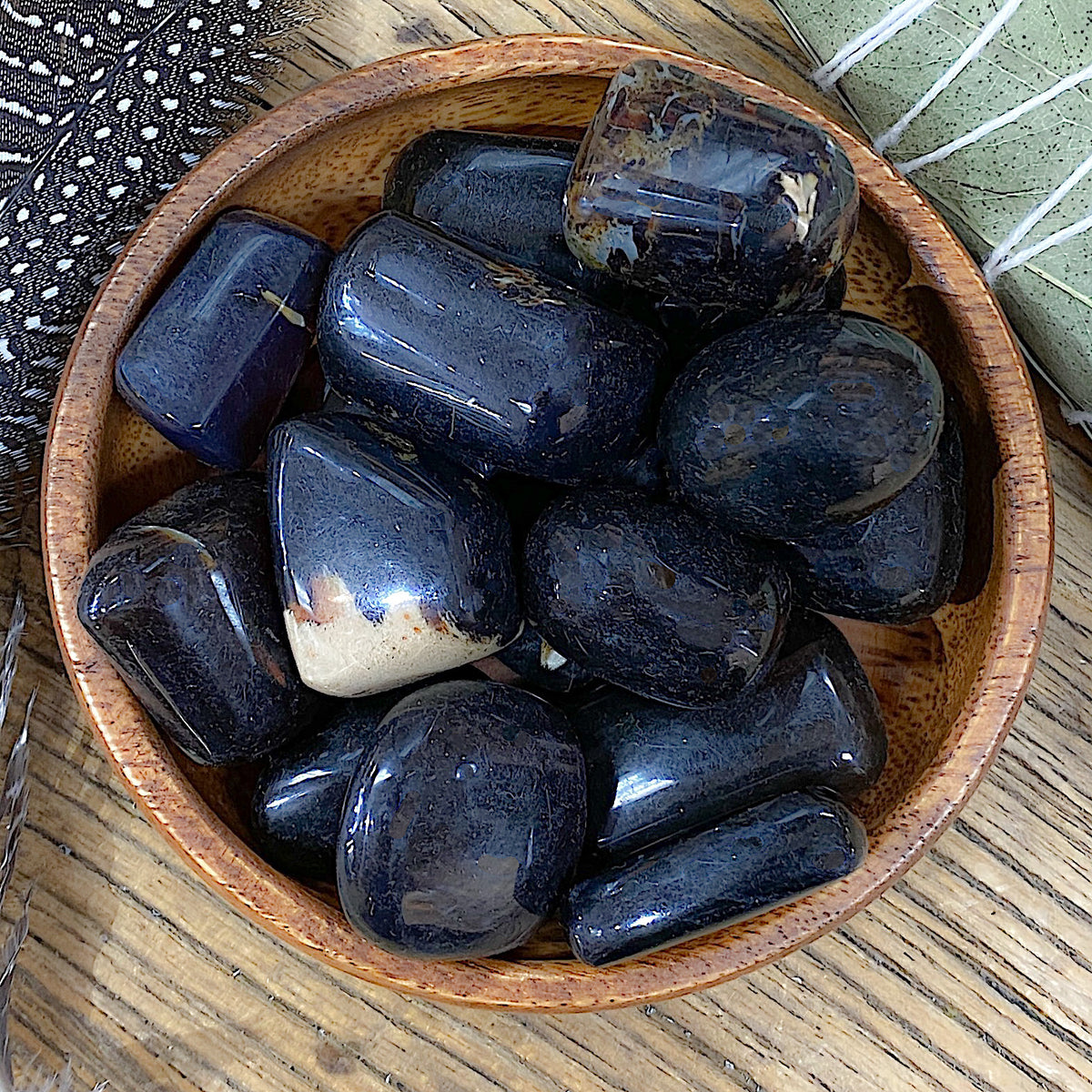 Overhead shot of various Sumatran Amber tumbled stones in a small bowl.