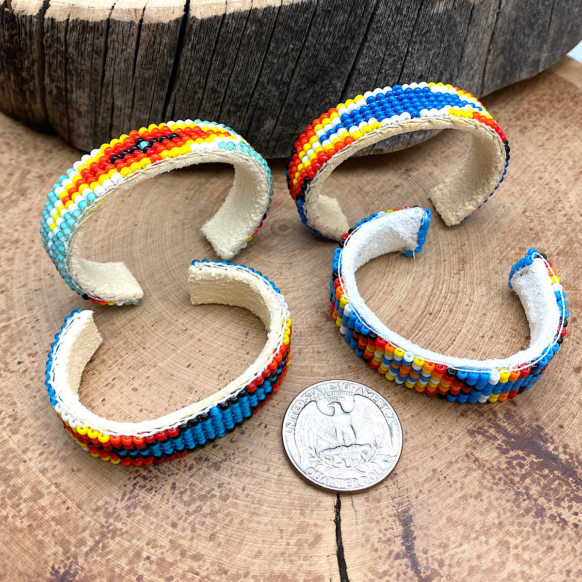 Comparison shot of a US quarter coin and Beaded baby bracelets of various patterns and colors laid together