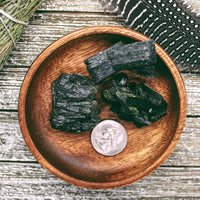 Size comparison of a US Quarter coin and multiple Epidote clusters in a small bowl