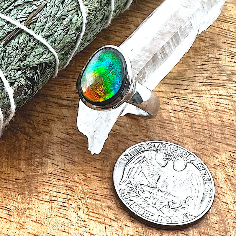 Comparison shot of a US quarter coin and an Ammolite ring