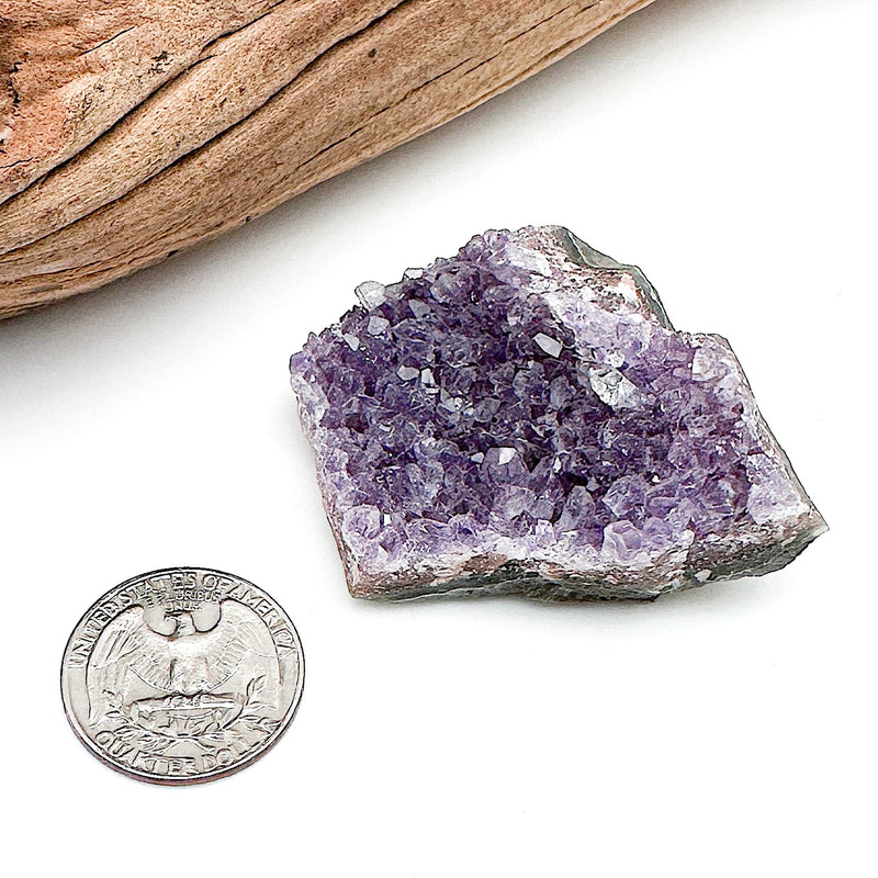 A comparison shot of a US quarter coin and an amethyst cluster