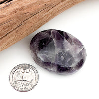 Comparison shot of a US quarter coin and an Amethyst palm stone