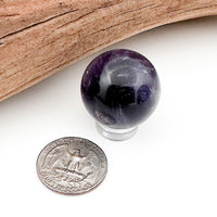 A comparison shot of an amethyst sphere and a US quarter coin