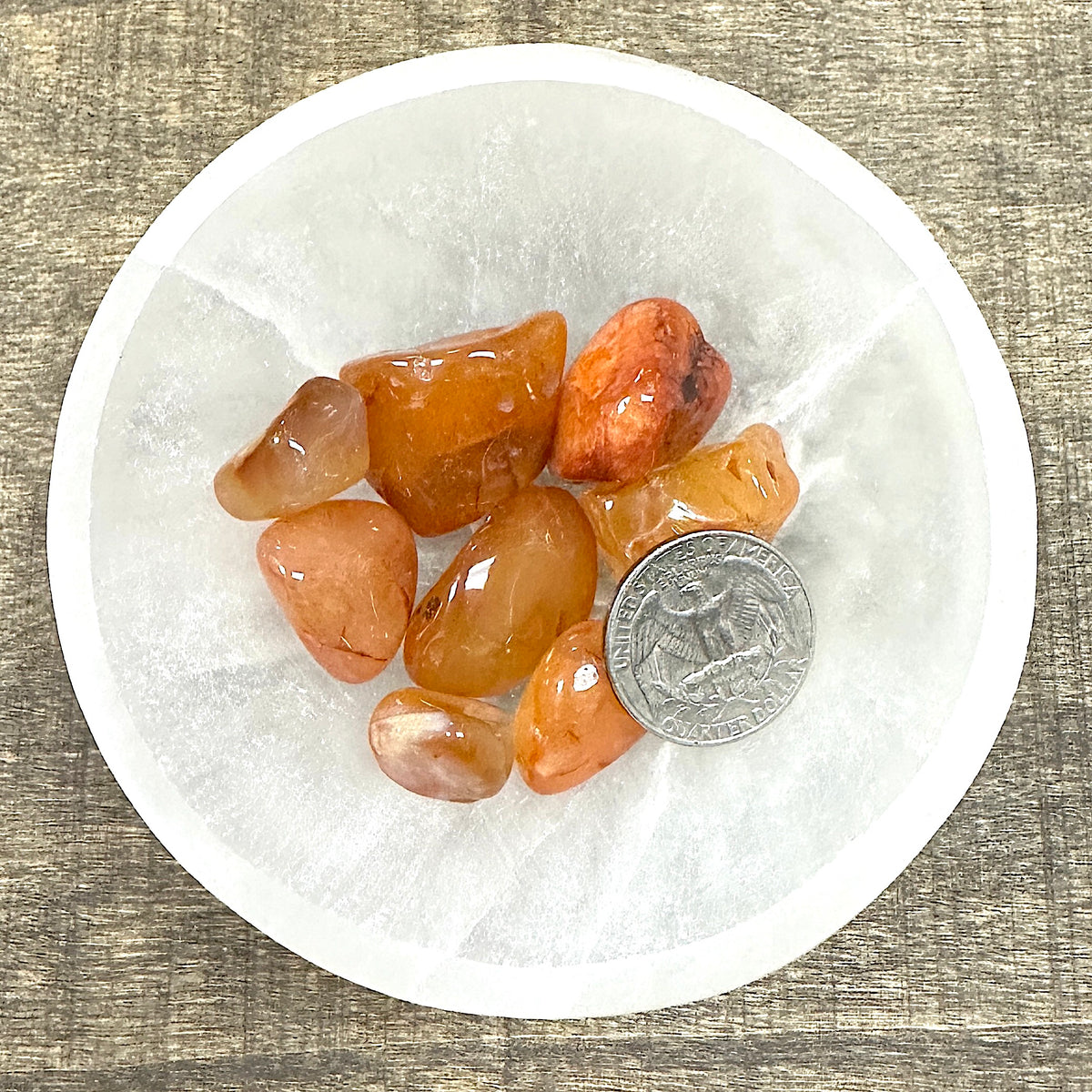 Comparison shot of a US quarter coin and various carnelian tumbled stones