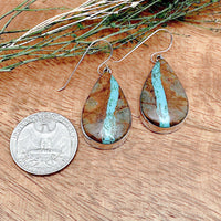 Comparison shot of a pair of boulder turquoise earrings and a US quarter coin