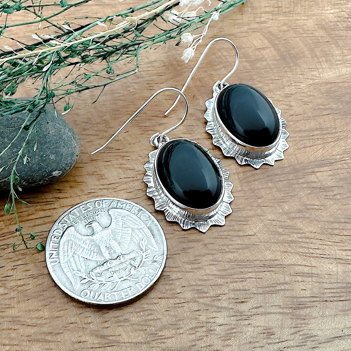Comparison shot of a US quarter coin and a set of two Black Onyx earrings in an oval shape