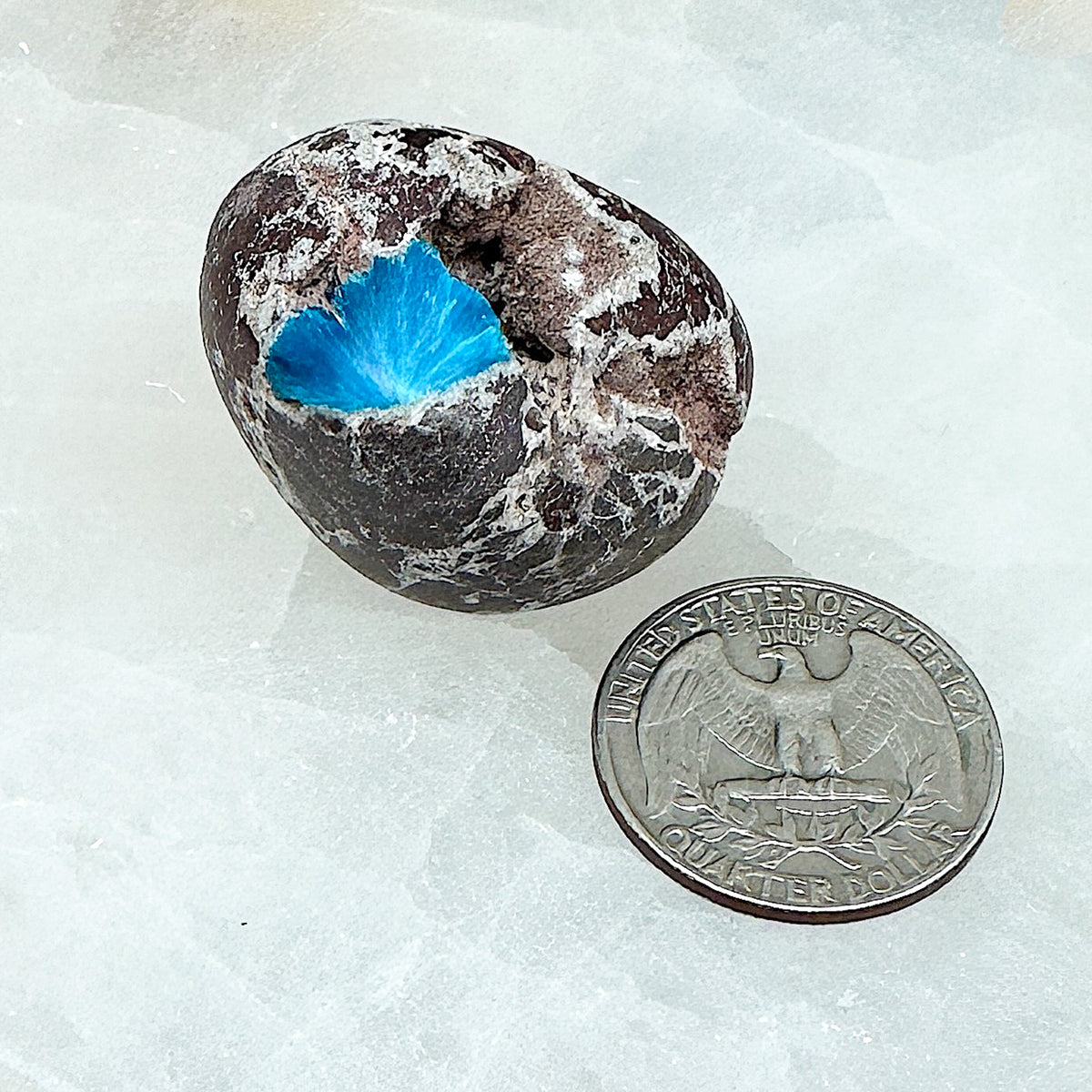 Comparison shot of a US quarter coin and a cavansite tumbled stone