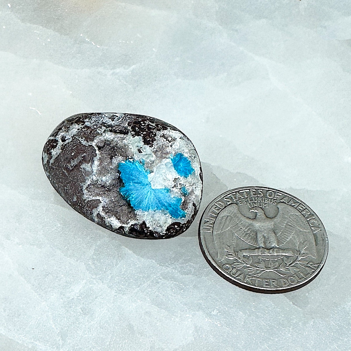 Comparison shot of a US quarter coin and a cavansite tumbled stone