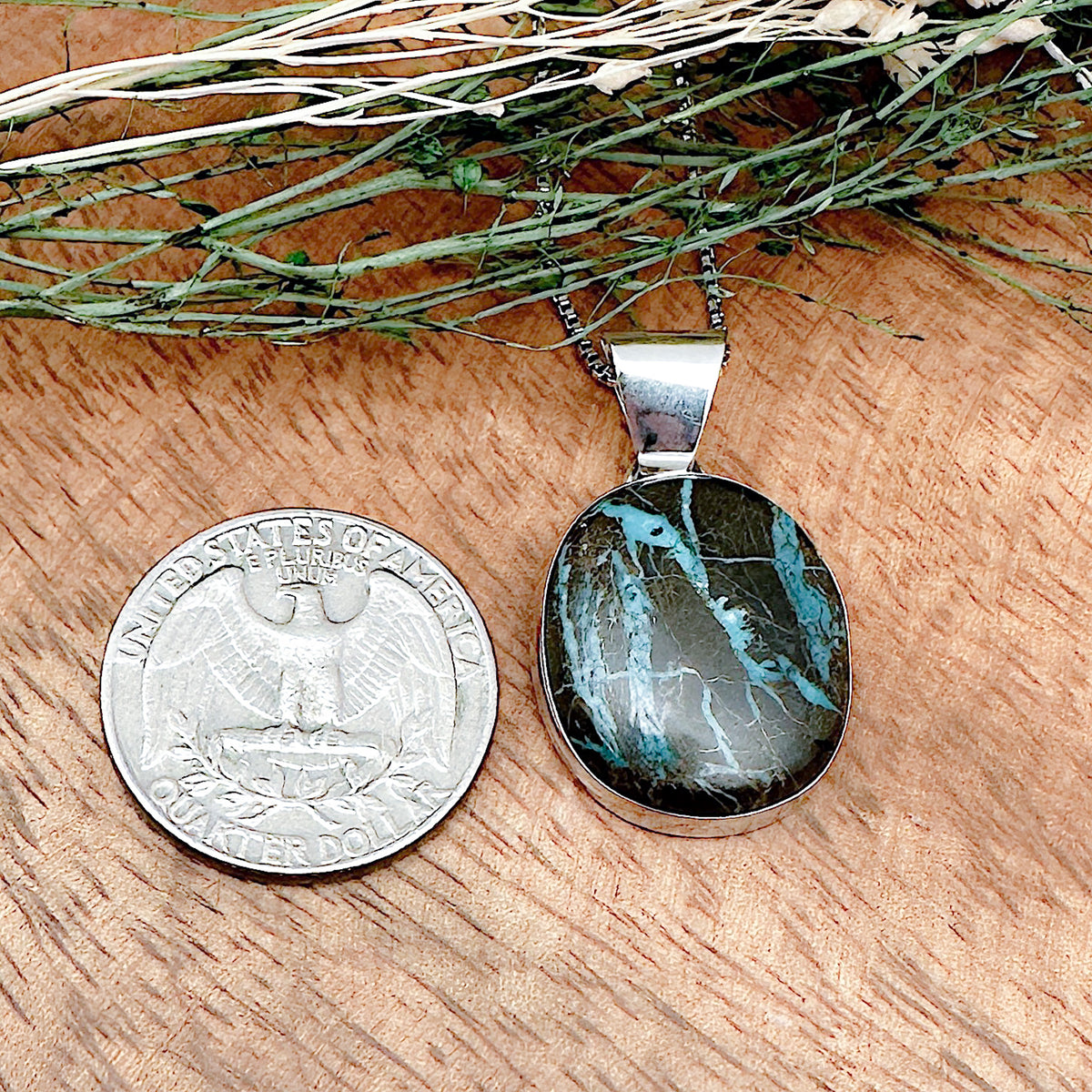 Comparison shot of a US quarter coin and a boulder turquoise pendant
