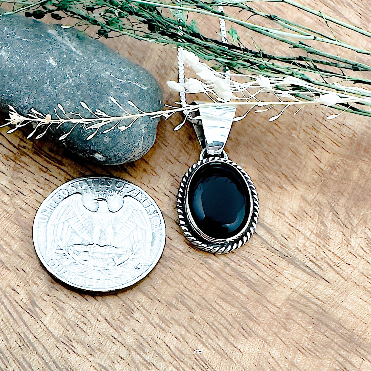 Comparison shot of a US quarter coin and a black onyx pendant