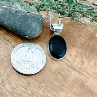 Comparison of a US quarter coin and a black onyx pendant