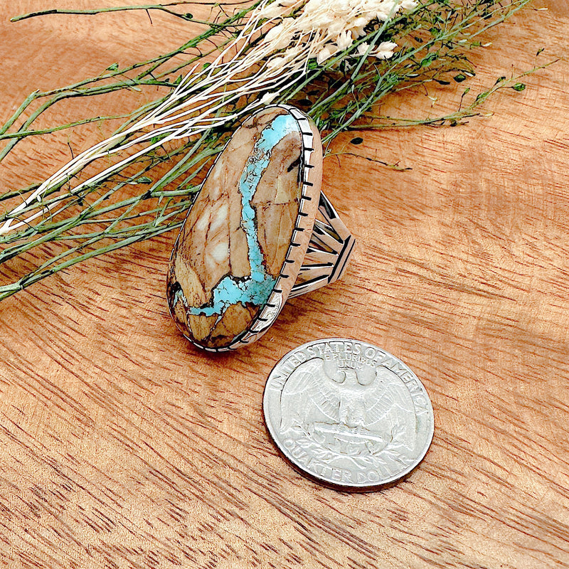 Comparison shot of a US quarter coin and a boulder turquoise ring