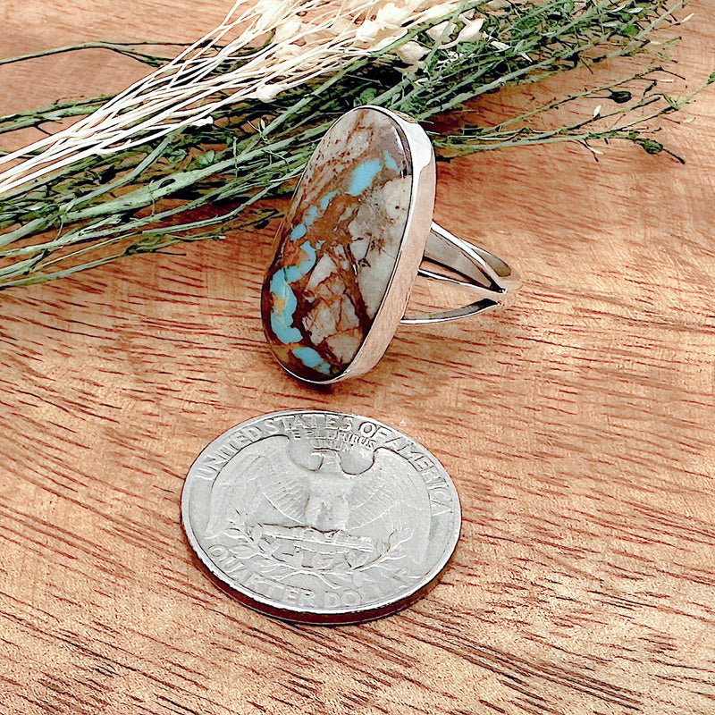 Comparison shot of a US quarter coin and a boulder turquoise ring