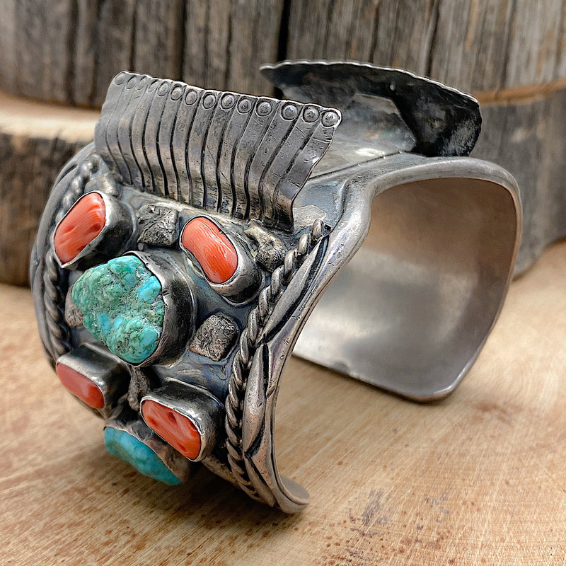 A large Native handmade sterling silver vintage watch cuff with natural sleeping beauty nugget turquoise and natural Mediterranean Red Coral set into the bracelet.